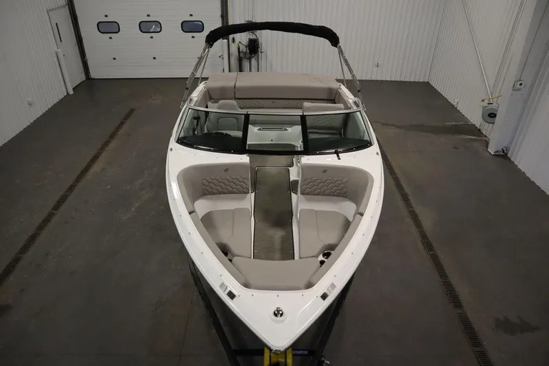Slide: The Image of 2025 Four Winns H1 boat in a garage, showcasing sleek design and spacious seating. - 2