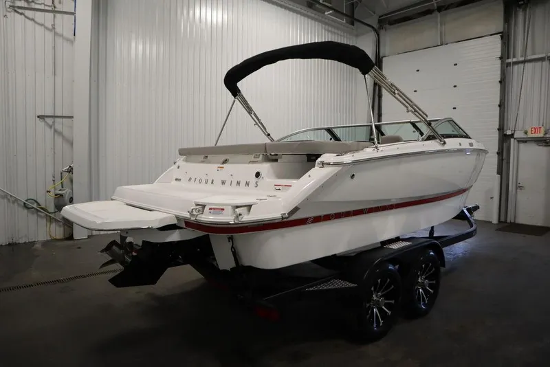 Slide: The Image of 2025 Four Winns H1 boat in a garage, white exterior, on a trailer. - 20