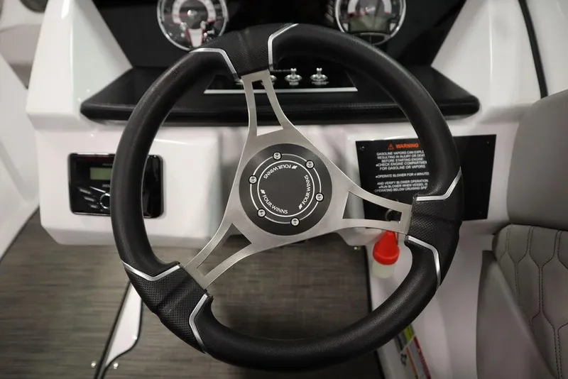 Slide: The Image of Steering wheel of 2025 Four Winns H1 boat, featuring modern design and controls. - 32