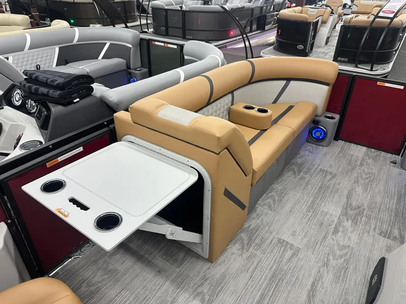 Slide: The Image of 2025 Crest Classic 220 pontoon boat interior with tan seating and fold-out table. - 6
