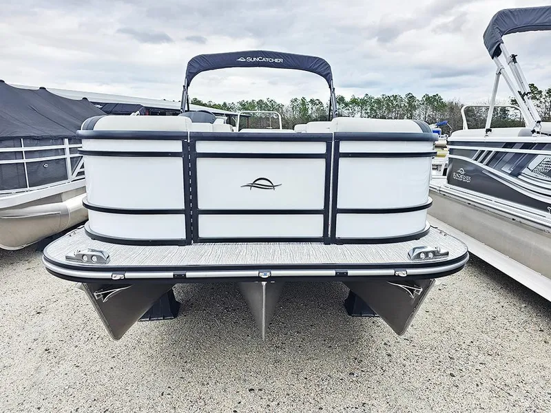 Slide: The Image of 2025 SunCatcher Select 322C pontoon boat, docked, front view, overcast sky. - 3