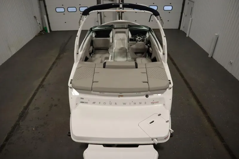 Slide: The Image of 2025 Four Winns H2 boat interior, featuring spacious seating and modern design in a garage setting. - 16