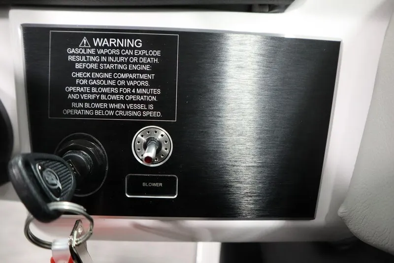 Slide: The Image of Control panel of 2025 Four Winns H2 boat with safety warning and ignition key. - 26