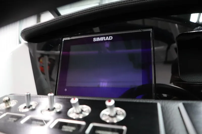Slide: The Image of 2025 Four Winns H2 boat dashboard with Simrad display and control switches. - 28