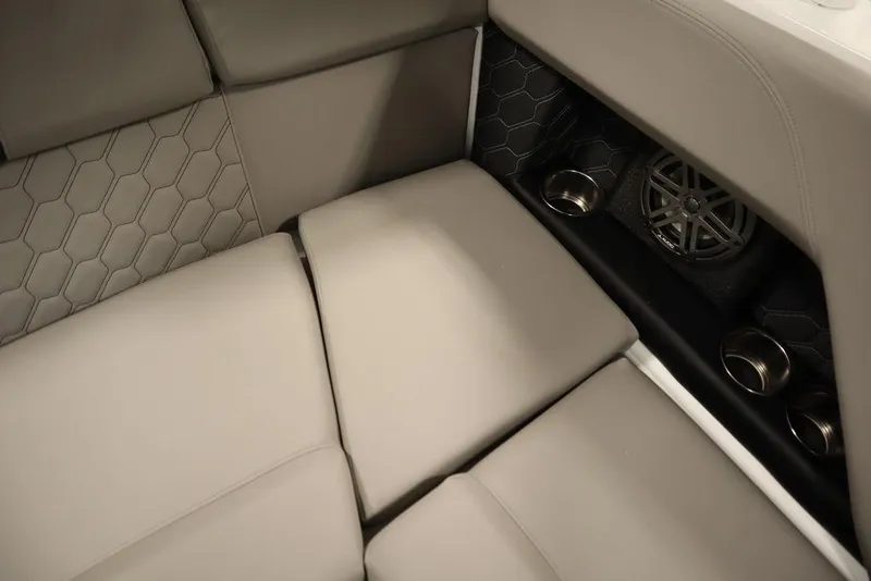 Slide: The Image of 2025 Four Winns H2 boat interior with beige seating, cup holders, and speaker. - 35