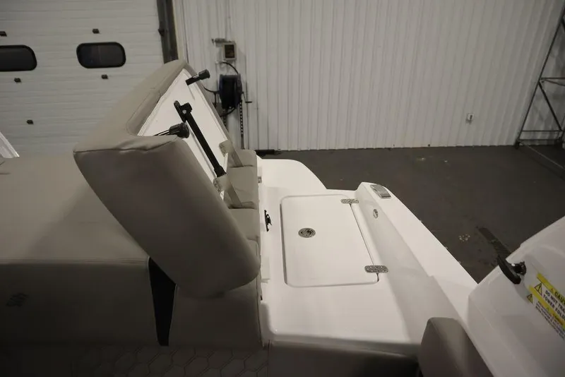 Slide: The Image of 2025 Four Winns H2 boat interior with beige seating and white deck in a garage setting. - 46