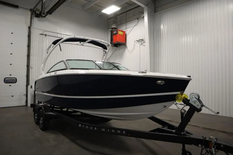 Slide: The Image of 2025 Four Winns H2 boat in a garage, on a trailer, with sleek design. - 7