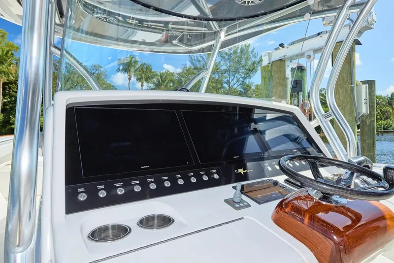 Slide: The Image of 2020 Valhalla Boatworks 41 helm with dual screens and steering wheel, docked by water. - 14