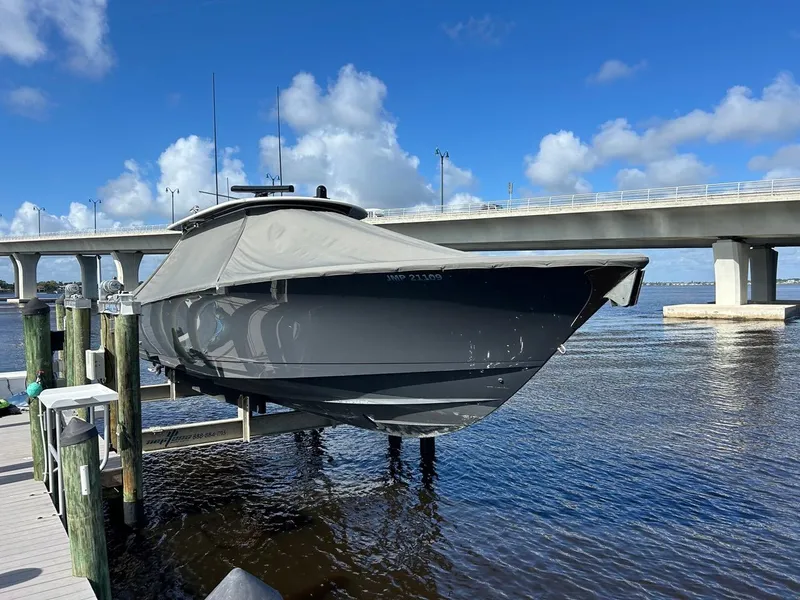 Slide: The Image of 2020 Valhalla Boatworks 41 on lift, docked near bridge under blue sky. - 22
