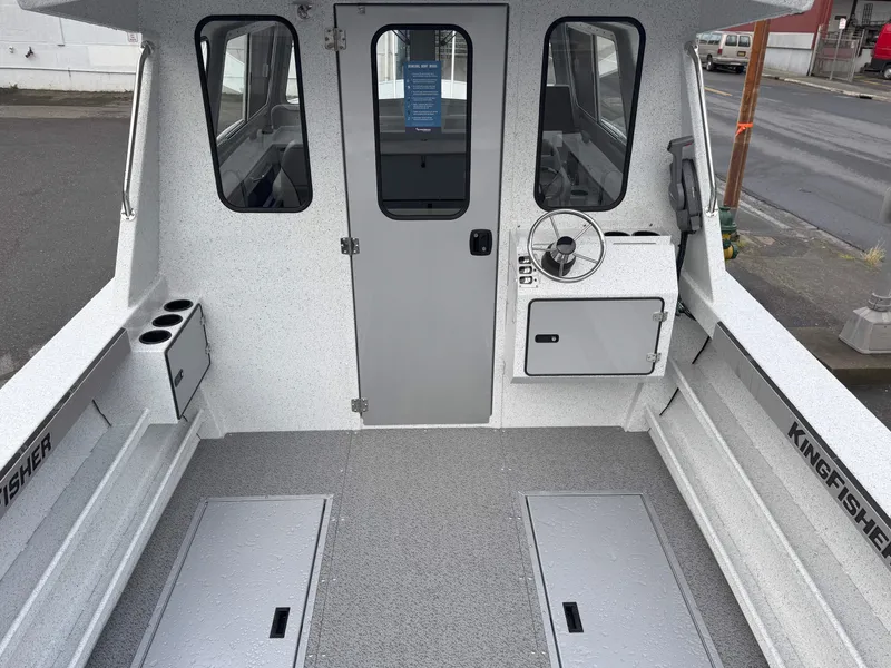 Slide: The Image of 2025 KingFisher 2625 Coastal Express boat interior with steering wheel and storage compartments. - 6