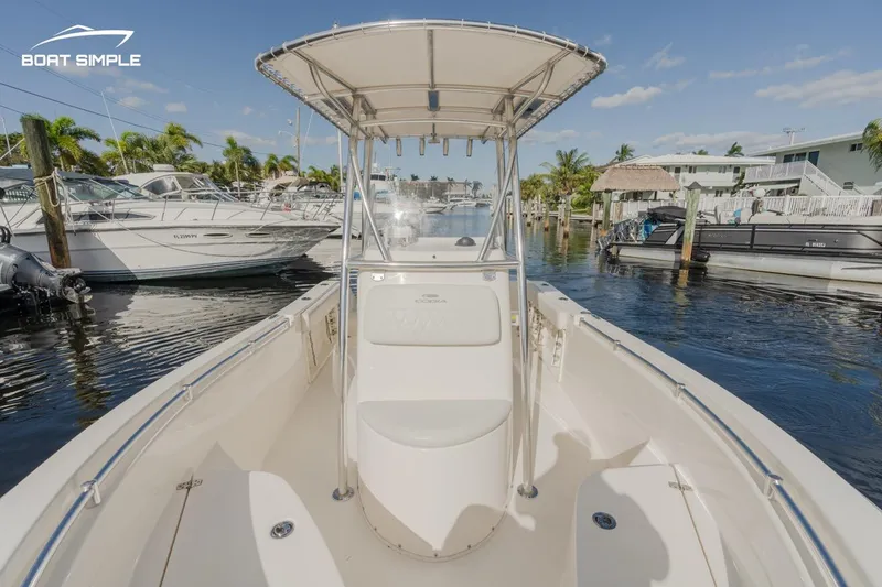 Slide: The Image of 2022 Cobia 201 Center Console boat docked in a sunny marina. - 7