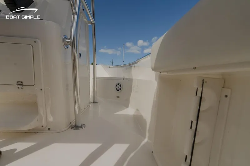 Slide: The Image of 2022 Cobia 201 Center Console boat interior with stainless steel fixtures under a clear blue sky. - 9