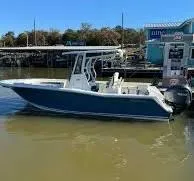 Slide: The Image of 2020 Tidewater 252 boat docked at marina, blue hull, sunny day. - 2
