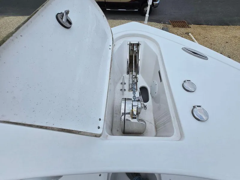 Slide: The Image of 2020 Tidewater 252 boat anchor compartment with open hatch and visible chain mechanism. - 3