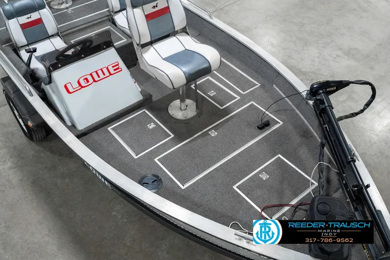 Slide: The Image of 1990 Lowe 1700 boat interior with seating and control panel, featuring Reeder-Trausch Marine branding. - 11