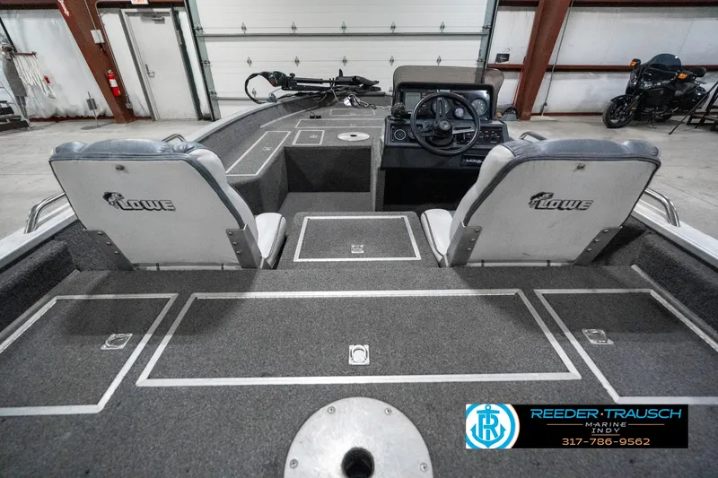 Slide: The Image of 1990 Lowe 1700 boat interior with dual seats and steering console in a garage setting. - 14