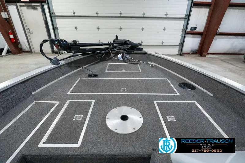 Slide: The Image of 1990 Lowe 1700 boat interior with storage compartments and trolling motor in a garage. - 16