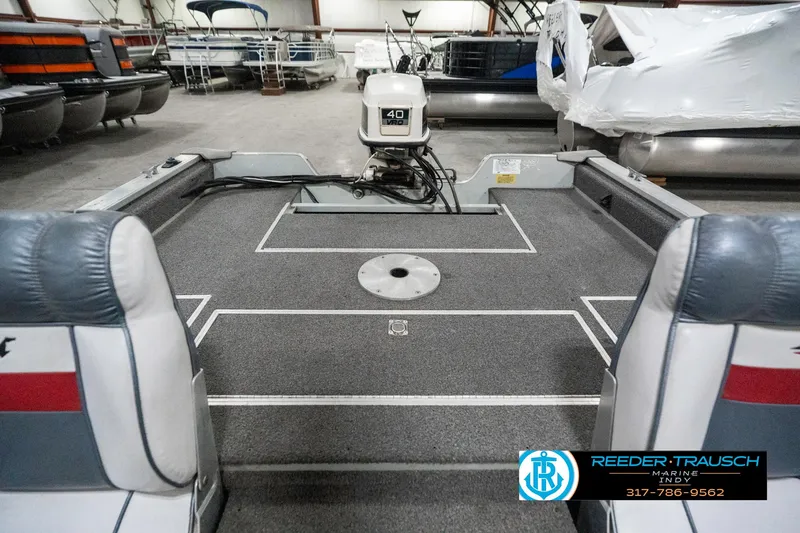 Slide: The Image of 1990 Lowe 1700 boat interior with motor, in a showroom setting. - 19