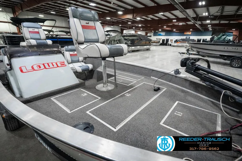 Slide: The Image of 1990 Lowe 1700 boat interior with seating and storage compartments in a showroom. - 20