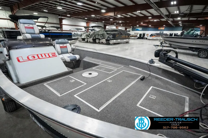 Slide: The Image of 1990 Lowe 1700 boat interior in showroom, featuring seating and storage compartments. - 21
