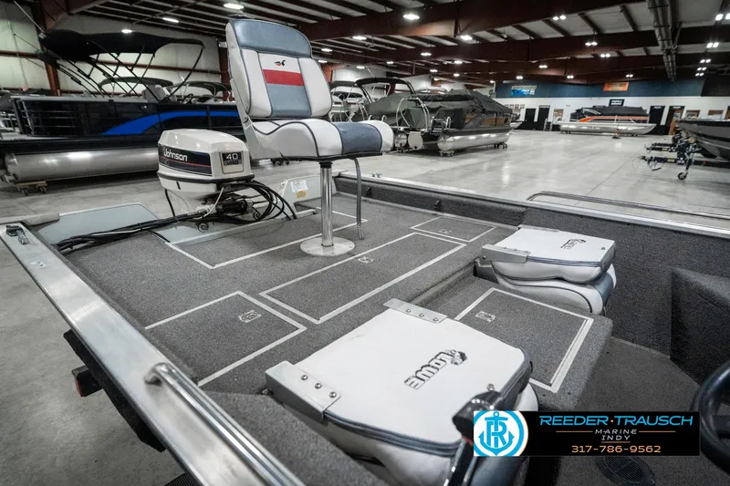 Slide: The Image of 1990 Lowe 1700 boat interior with seating and motor in showroom. - 23