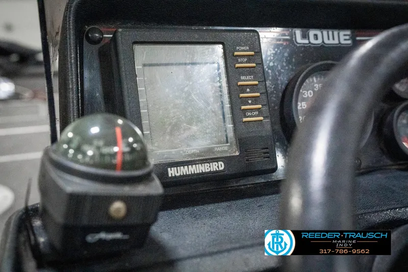 Slide: The Image of Dashboard of a 1990 Lowe 1700 boat featuring a Humminbird fish finder and compass. - 29