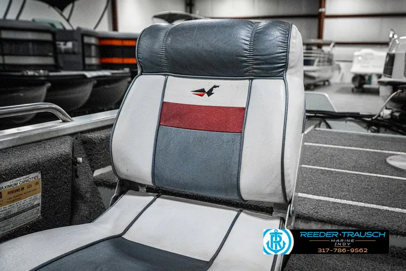 Slide: The Image of Boat seat in a 1990 Lowe 1700, featuring a red and gray design in a showroom. - 33