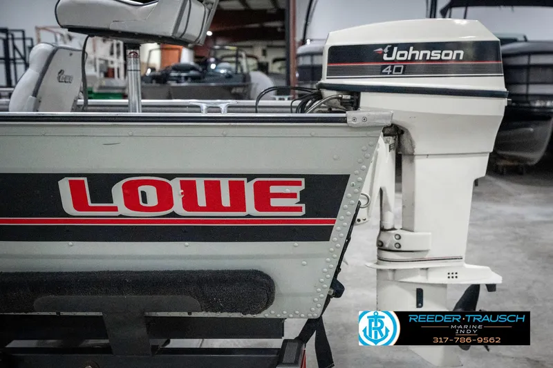 Slide: The Image of 1990 Lowe 1700 boat with Johnson 40 outboard motor in a showroom. - 40