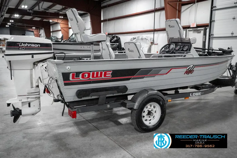 Slide: The Image of 1990 Lowe 1700 boat with Johnson outboard motor on trailer in indoor storage. - 6