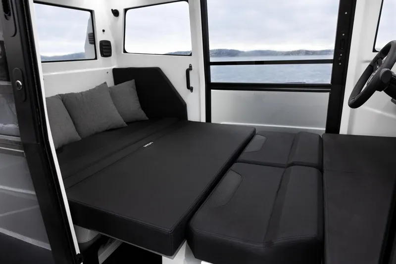 Slide: The Image of Interior of 2025 Iron 827C with convertible seating and cushions, overlooking water. - 3