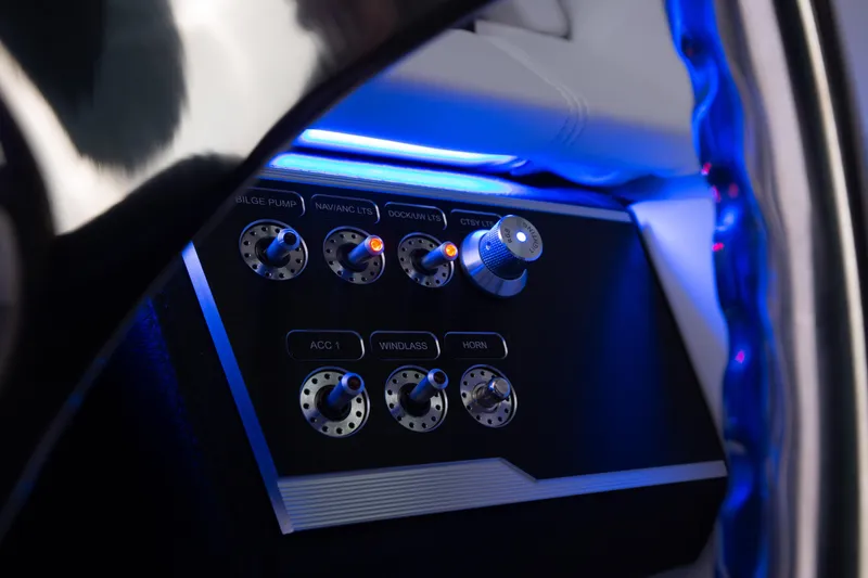 Slide: The Image of Control panel of 2025 Four Winns HD5 OB boat with illuminated switches and knobs. - 11