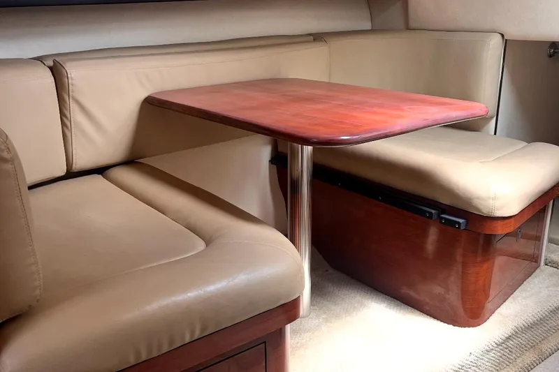 Slide: The Image of 2007 Sea Ray Amberjack interior with beige leather seating and wooden table. - 26