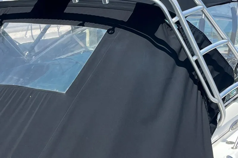 Slide: The Image of 2007 Sea Ray Amberjack boat with black canvas cover and metal frame. - 35