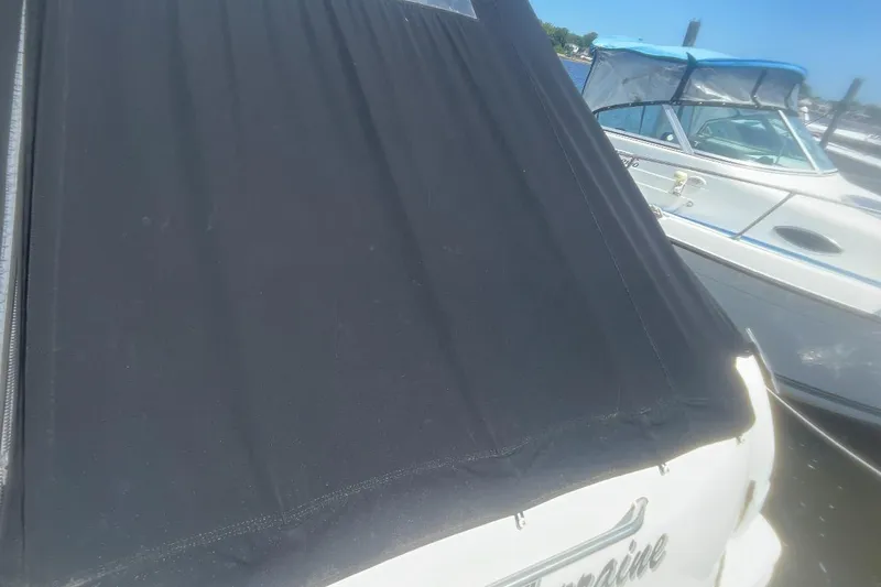 Slide: The Image of 2007 Sea Ray Amberjack with black cover docked beside another boat. - 37