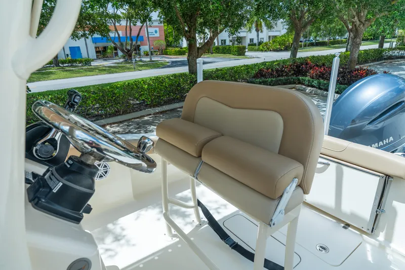 Slide: The Image of 2023 Scout 215 XSF boat interior with steering wheel and cushioned seating. - 11