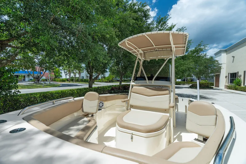 Slide: The Image of 2023 Scout 215 XSF boat with seating, under a clear sky, surrounded by trees. - 9