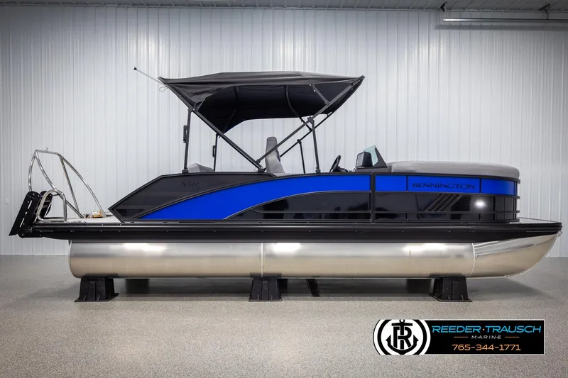 Slide: The Image of 2025 Bennington 22 MSBSE pontoon boat with blue accents in a showroom. - 5