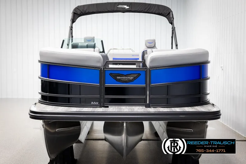 Slide: The Image of 2025 Bennington 22 MSBSE pontoon boat with blue and black exterior in showroom. - 8
