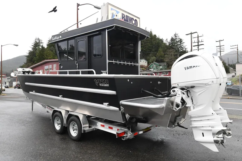 Slide: The Image of Custom 2025 24 LC boat on trailer with Yamaha engine, parked in urban setting. - 5