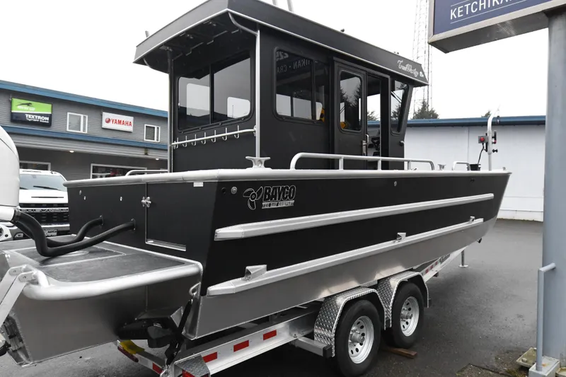 Slide: The Image of Custom 24 LC 2025 boat on trailer, sleek design, parked outside dealership. - 6