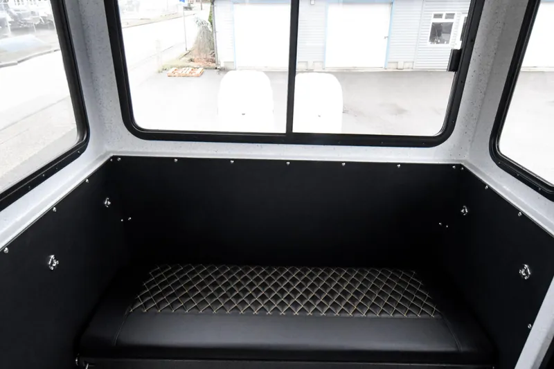 Slide: The Image of Interior of 2025 Custom 24 LC boat with quilted seating and large windows. - 9