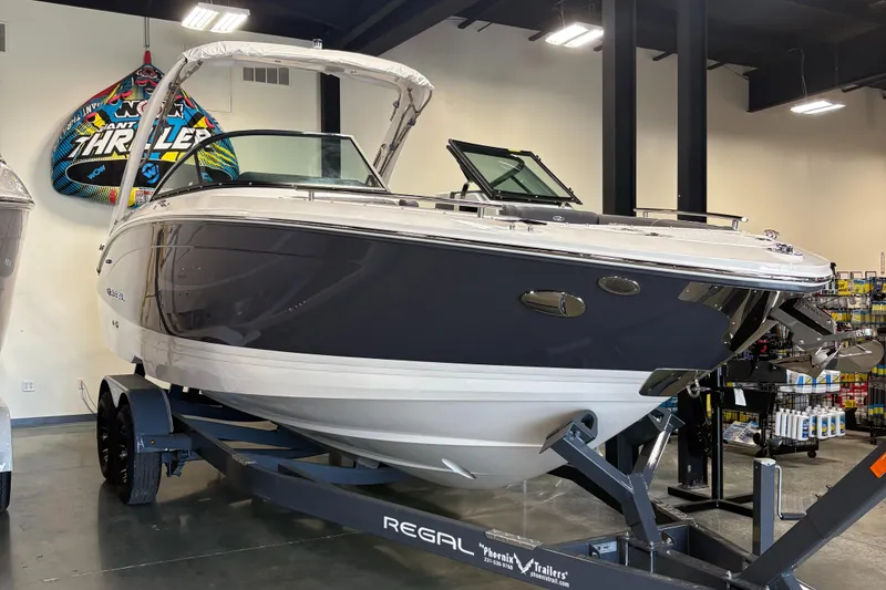 The Image of 2025 Regal LS6 boat on trailer in showroom, featuring sleek design and modern features. - 0