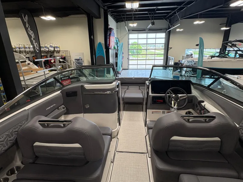Slide: The Image of 2025 Regal LS6 boat interior with gray seating and modern dashboard in showroom. - 10
