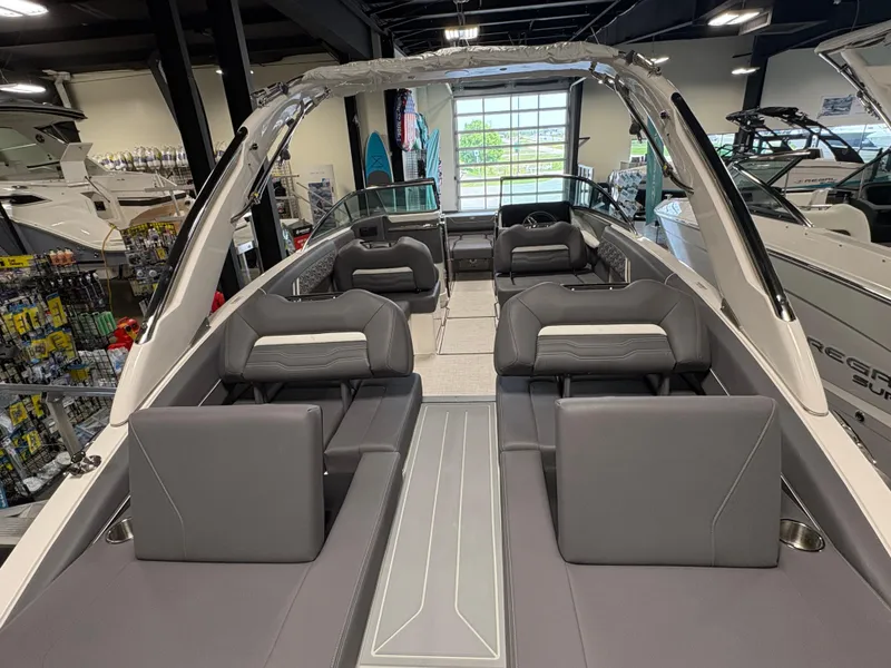 Slide: The Image of 2025 Regal LS6 boat interior with sleek gray seating and modern design in showroom. - 14