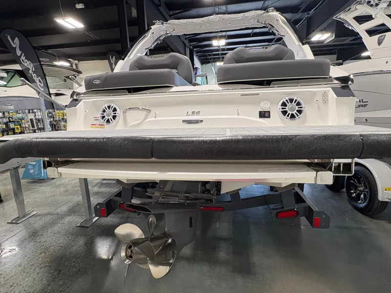 Slide: The Image of 2025 Regal LS6 boat rear view in showroom, showcasing dual speakers and propeller. - 18