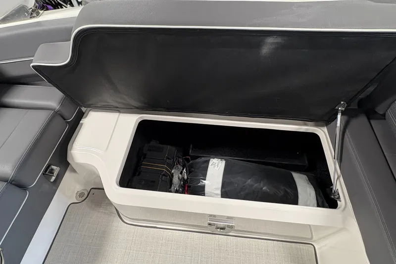 Slide: The Image of 2025 Regal LS6 boat storage compartment with open lid, revealing interior space. - 27