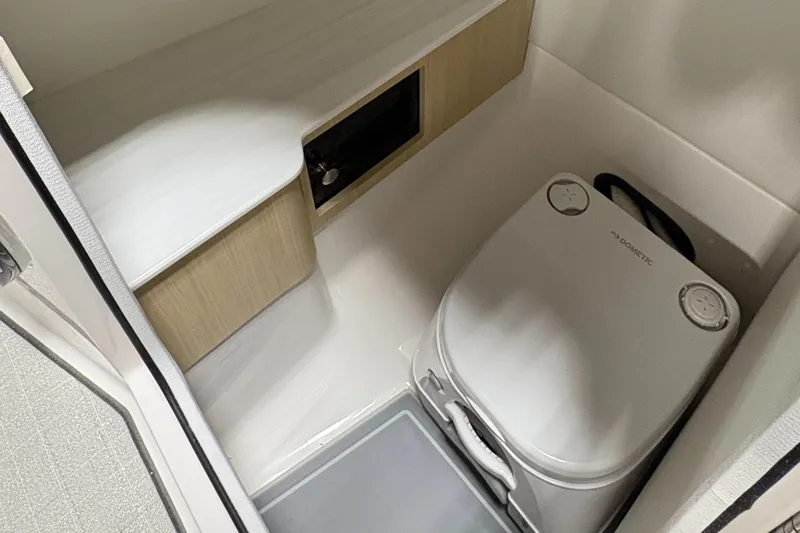 Slide: The Image of Compact bathroom in 2025 Regal LS6 boat with portable toilet and storage cabinet. - 28