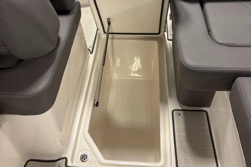 Slide: The Image of 2025 Regal LS6 boat storage compartment with open lid and cushioned seating. - 30