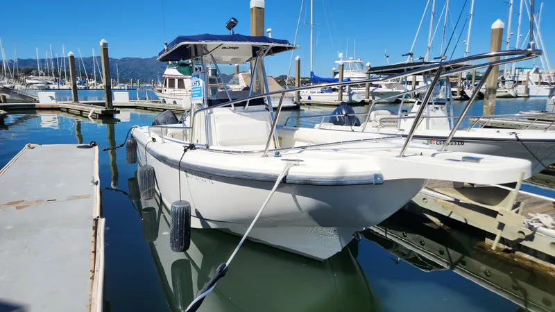 Slide: The Image of 2001 Boston Whaler 26 Outrage boat docked in a marina under clear blue skies. - 1