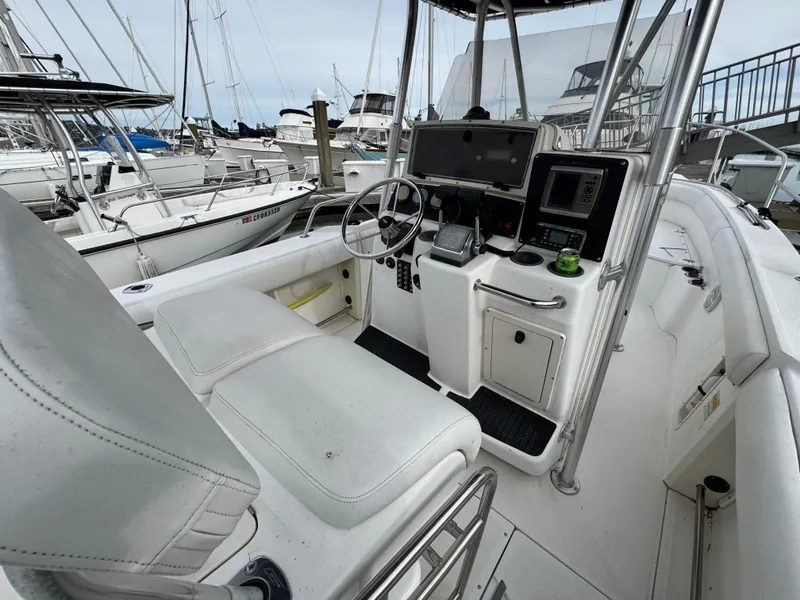 Slide: The Image of 2001 Boston Whaler 26 Outrage boat interior with steering console and seating at marina. - 20